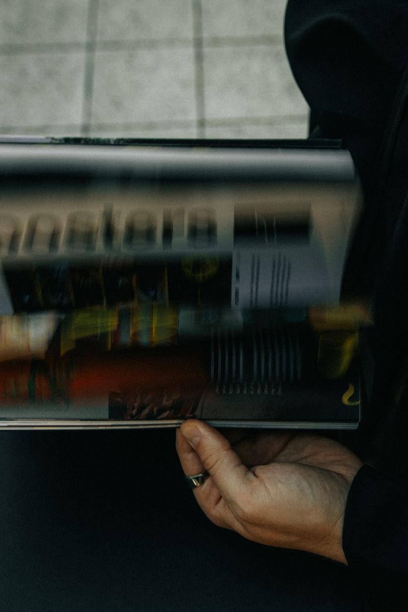 A hand holding a magazine as its pages blur mid-flip